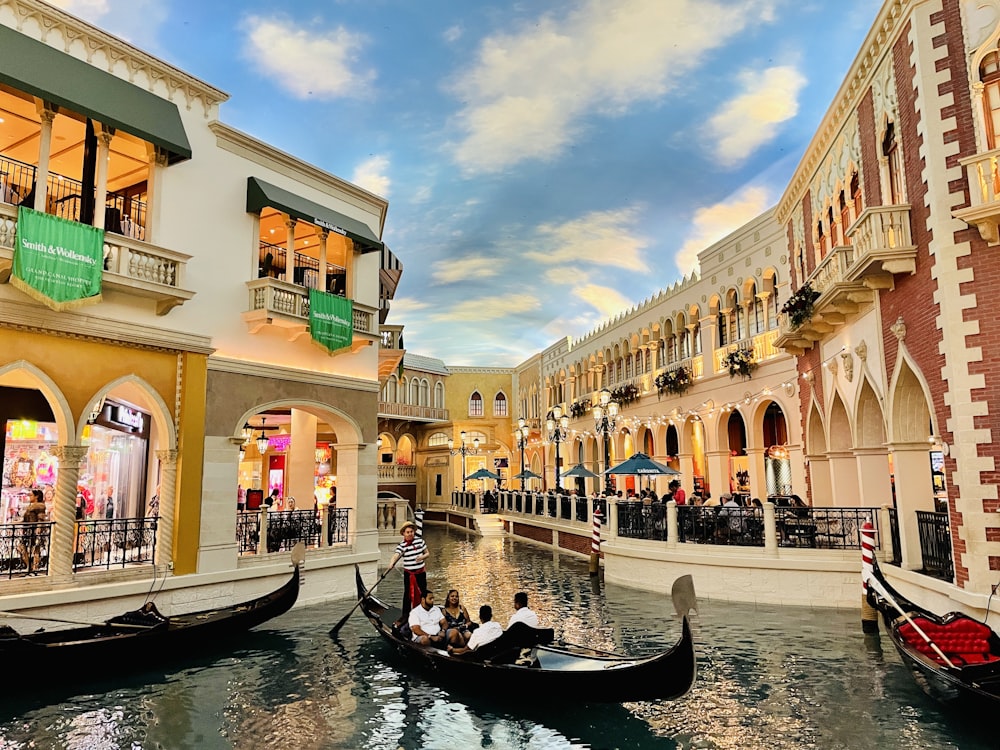 a group of people ride a boat through a canal