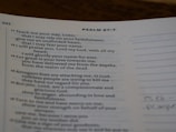 A page from a religious text showing Psalm 87:7, printed in clear black text on white paper. The verses discuss faithfulness and reliance on divine strength. The page is slightly curved, and there is marginal writing.