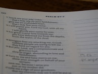 A page from a religious text showing Psalm 87:7, printed in clear black text on white paper. The verses discuss faithfulness and reliance on divine strength. The page is slightly curved, and there is marginal writing.