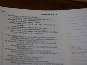 A page from a religious text showing Psalm 87:7, printed in clear black text on white paper. The verses discuss faithfulness and reliance on divine strength. The page is slightly curved, and there is marginal writing.