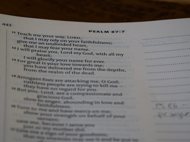 A page from a religious text showing Psalm 87:7, printed in clear black text on white paper. The verses discuss faithfulness and reliance on divine strength. The page is slightly curved, and there is marginal writing.