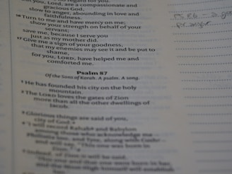 A close-up image of a page from a book with text, likely from a religious text or scripture. The text is in English, with references to Psalms and religious themes. There is handwriting on the margin, indicating notes or annotations.