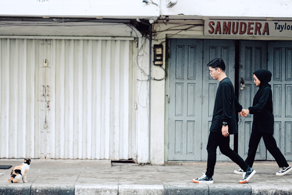 a couple of men walking down a sidewalk