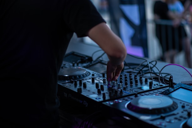 a dj working on a deck setup mixing tracks together at an outdoor event