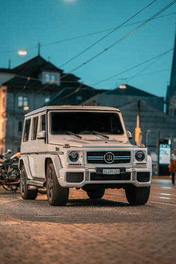 Luxury van parked in front of the Acropolis at dusk with golden light highlighting the vehicle's sleek design.