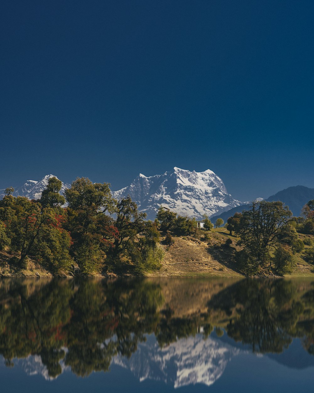 a lake with trees and mountains in the background