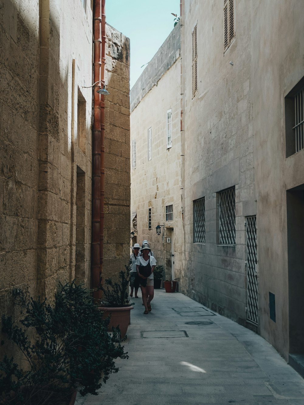 a group of people walking down a street between buildings