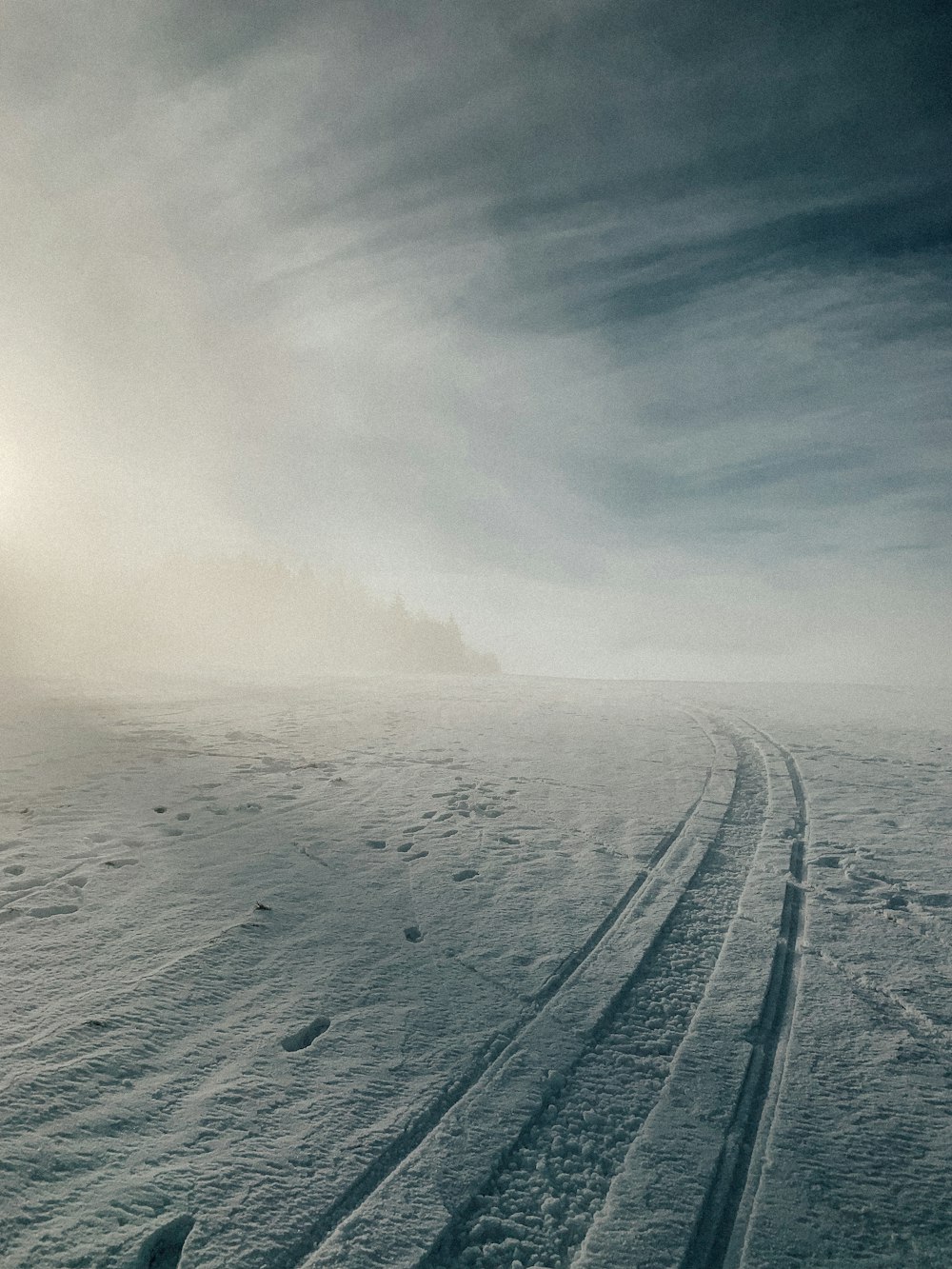 a snowy road with a cloudy sky