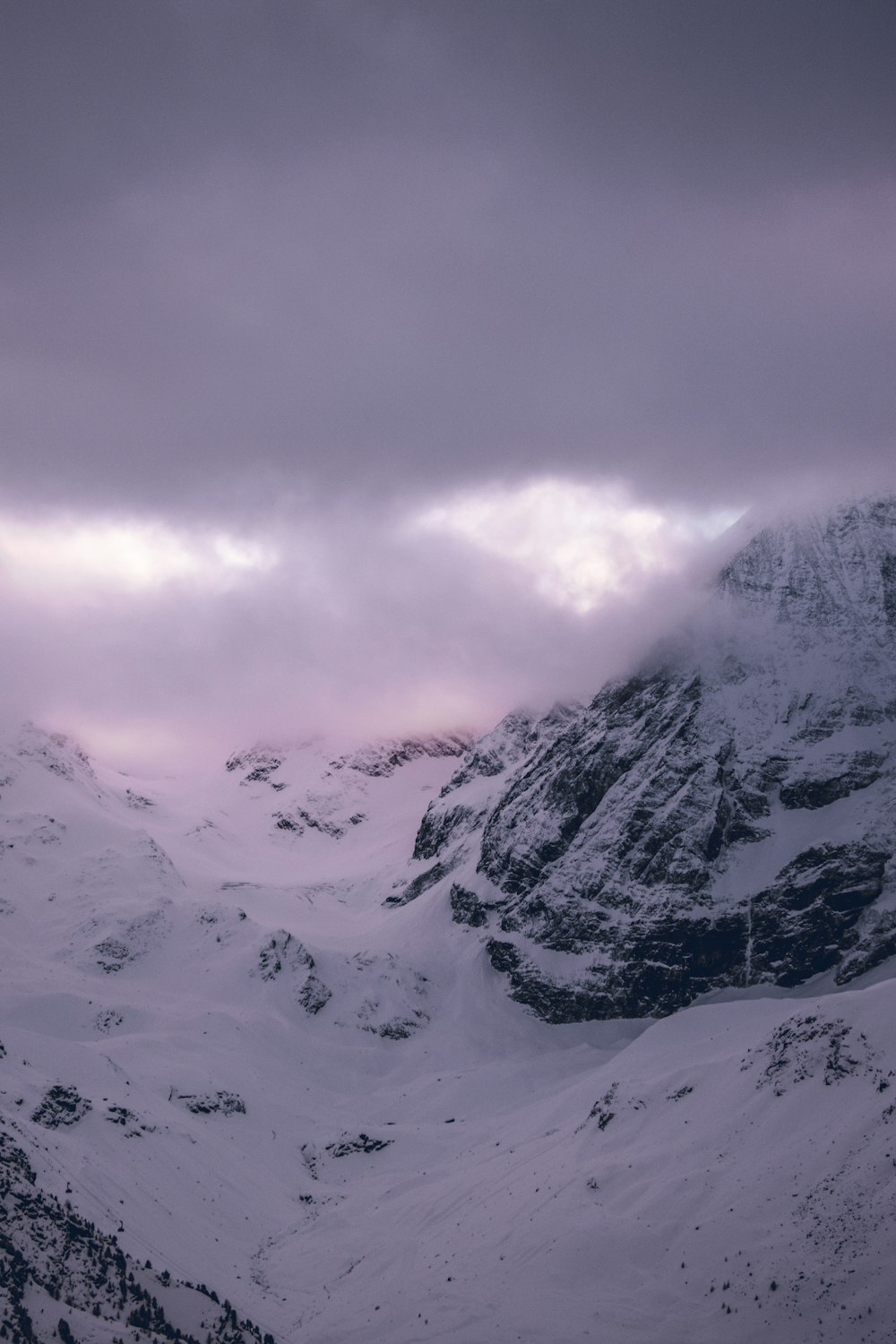 a snowy mountain with clouds