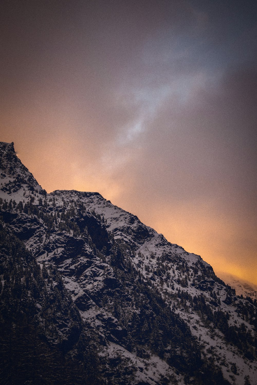 a snowy mountain with a cloudy sky