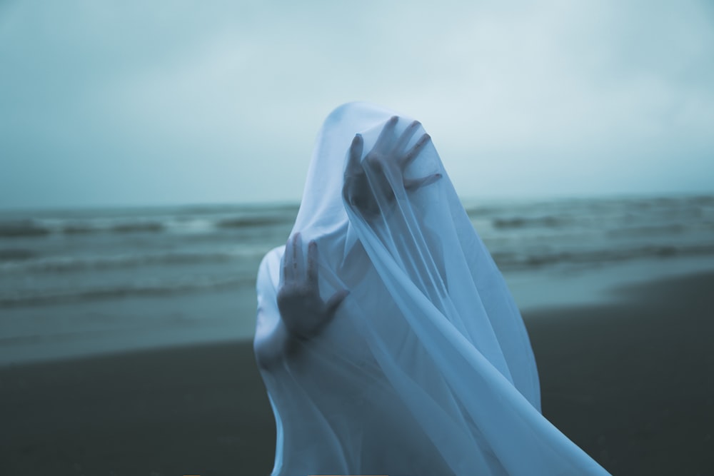 a hand with a white glove on a beach