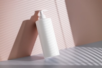 a hand holding a white bottle
