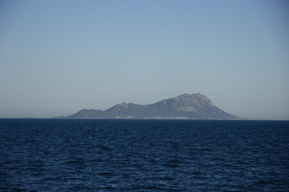 a body of water with a mountain in the distance