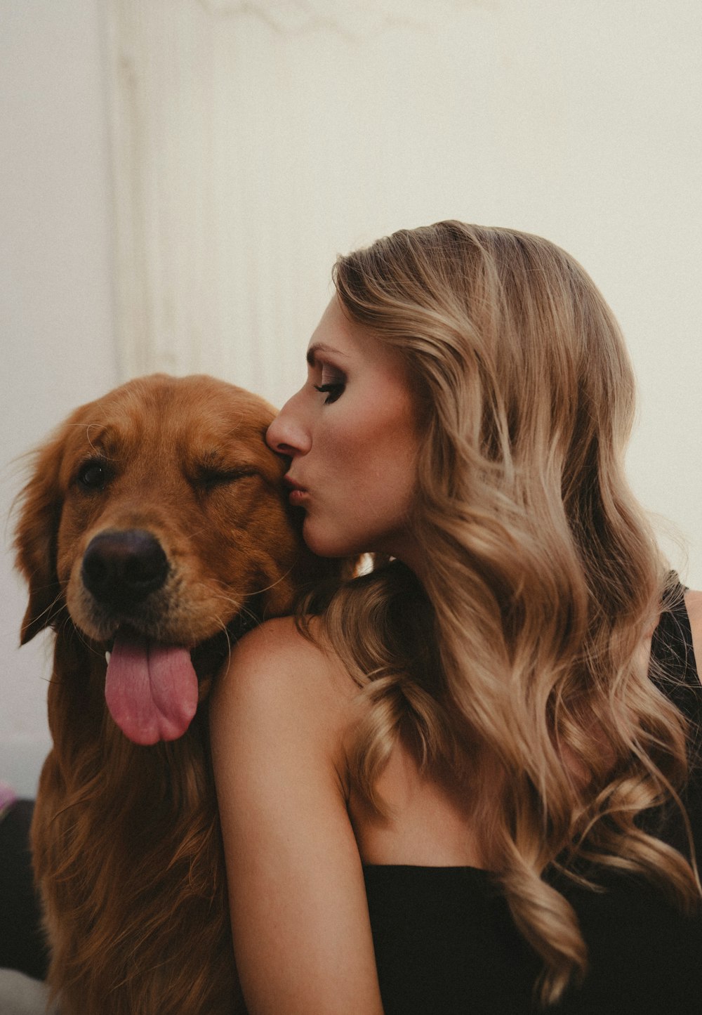 a woman kissing a dog