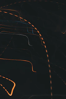 Close-up of a vibrant orange fluid graphic on a dark background, showcasing dynamic brush strokes.