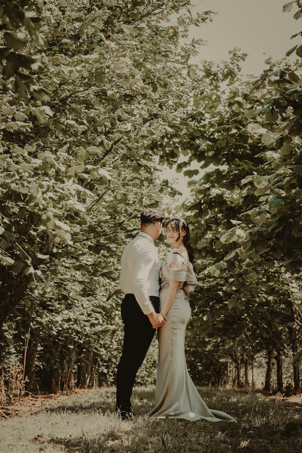 Un hombre y una mujer posando frente a un árbol en flor