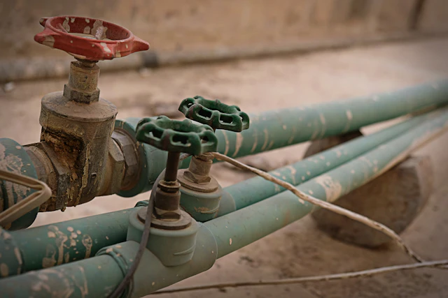 Old brass gate valves on green-painted pipes