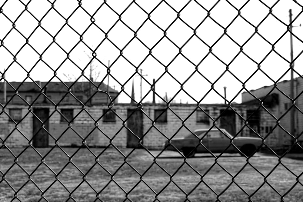 a fenced in area with a building behind it