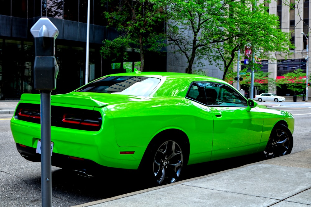 a green car parked on the side of a street