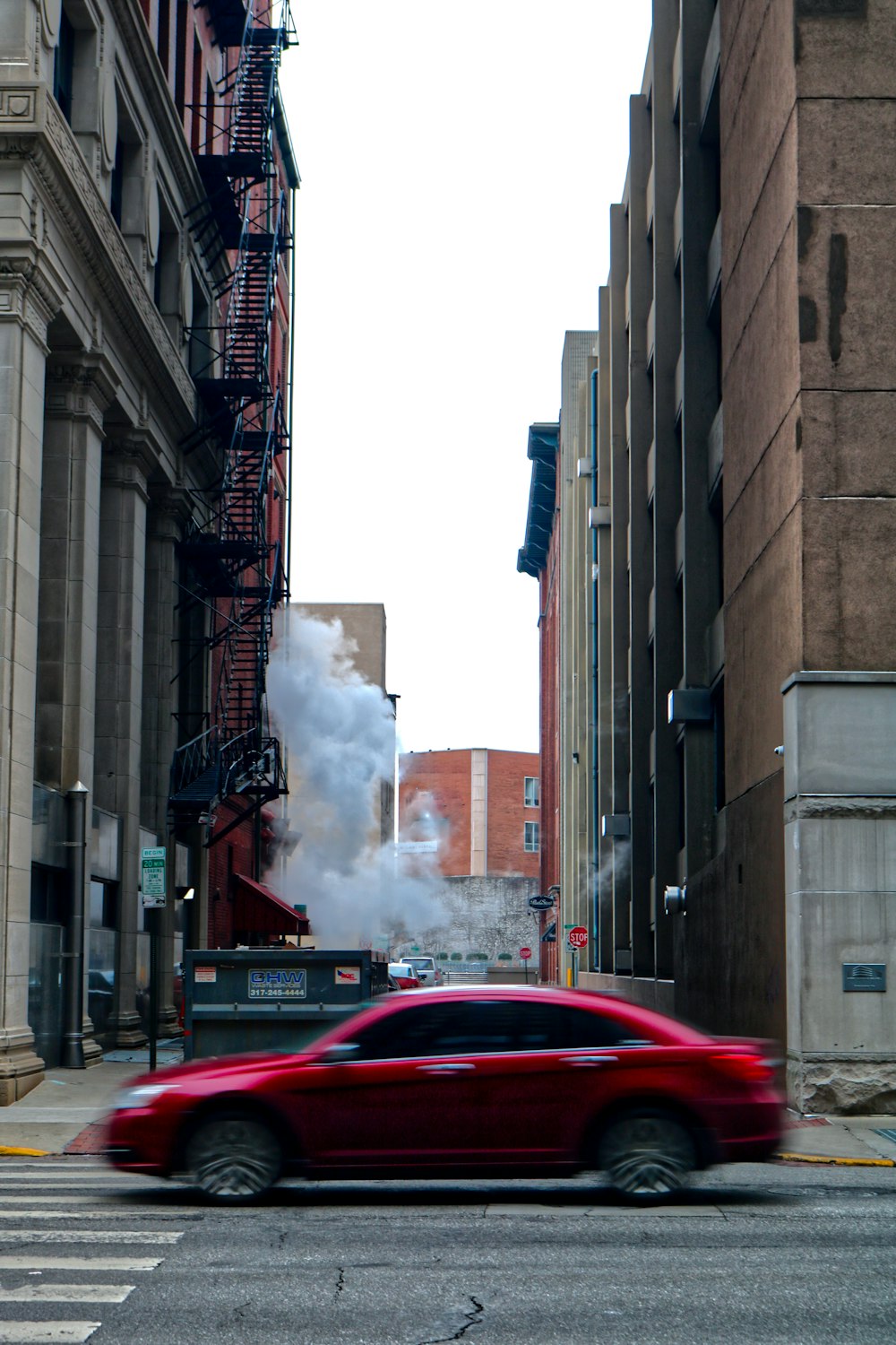 a car on a street with a fire coming out of the back