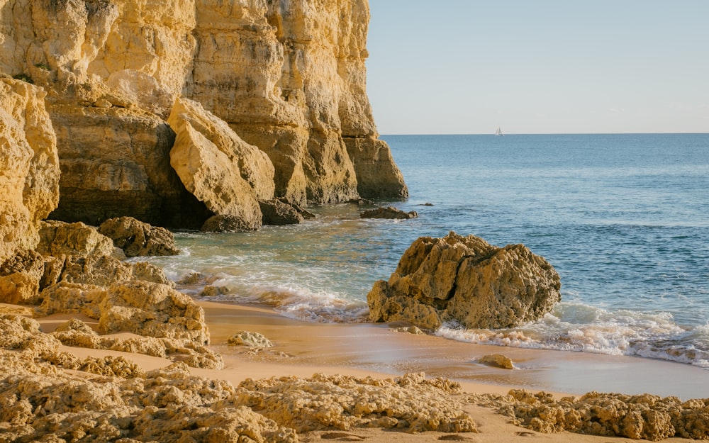 a rocky beach with a large body of water in the background