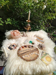A colorful altar with crystals, candles, and handwritten notes from recent energy restorations