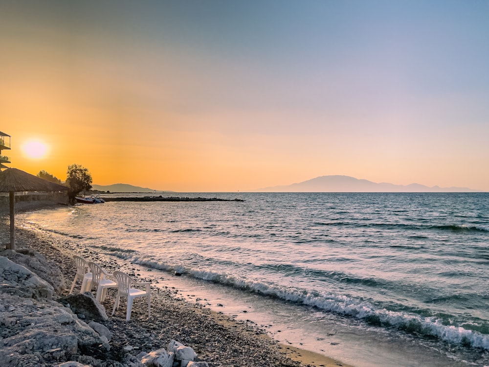 une plage avec un plan d’eau et un coucher de soleil