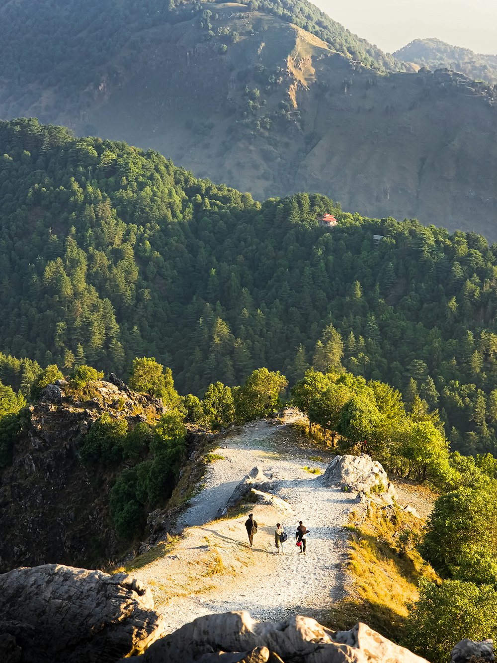 people walking on a rocky path in a mountainous region