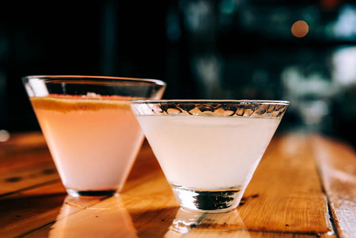 Dois coquetéis num bar de luz baixa, com e sem álcool