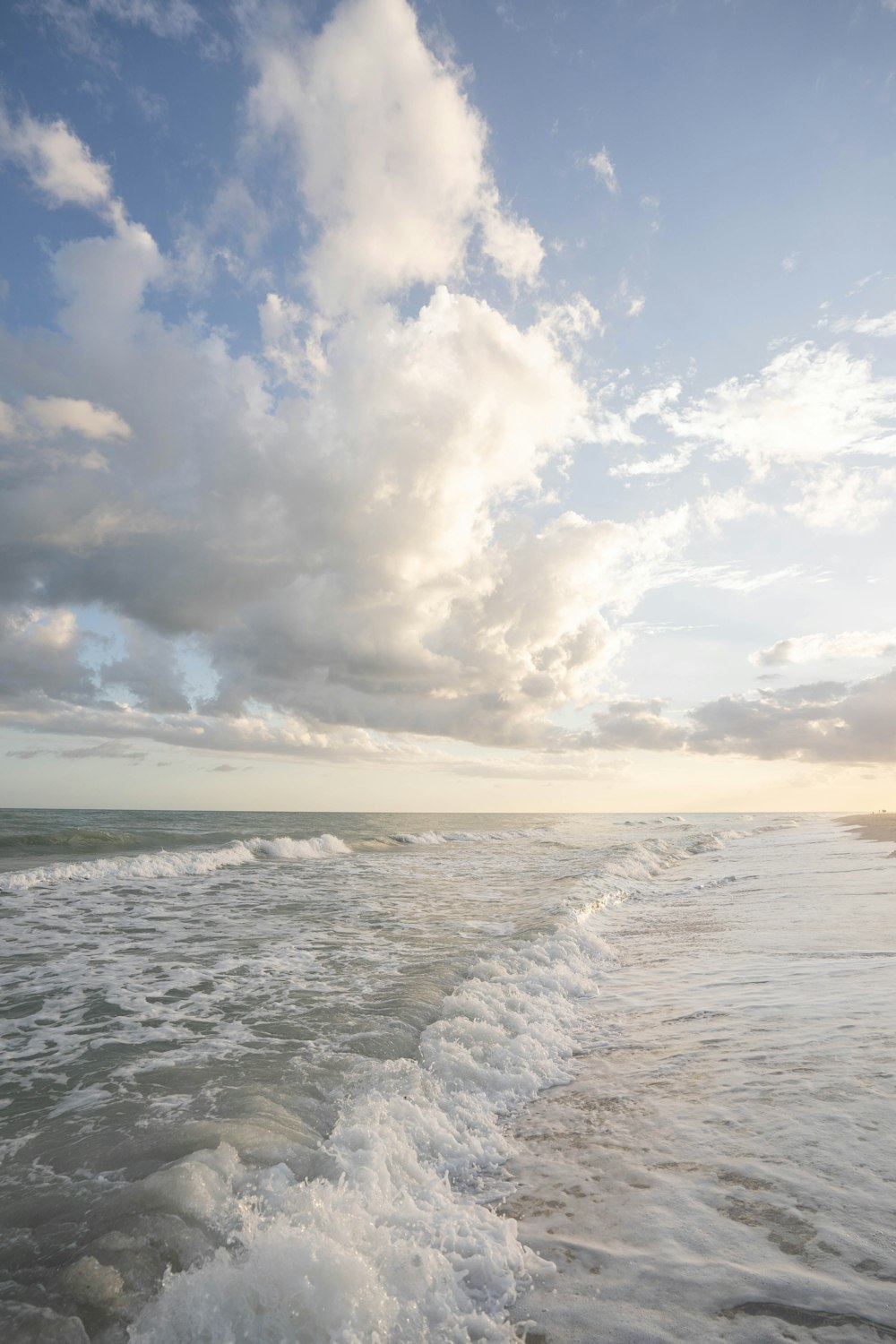 a body of water with clouds above it