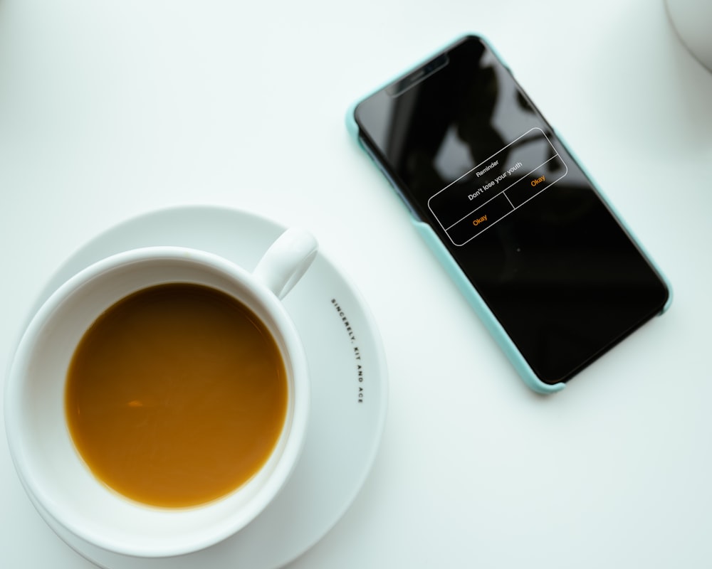 a cup of coffee and a cell phone