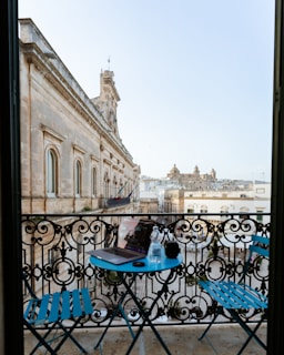 A guest enjoying a morning coffee on a private balcony with views of the estate's historic architecture.
