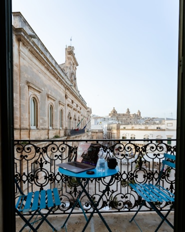 A guest enjoying a morning coffee on a private balcony with views of the estate's historic architecture.
