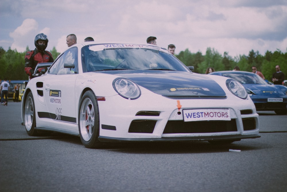 a white sports car with a person in the driver's seat