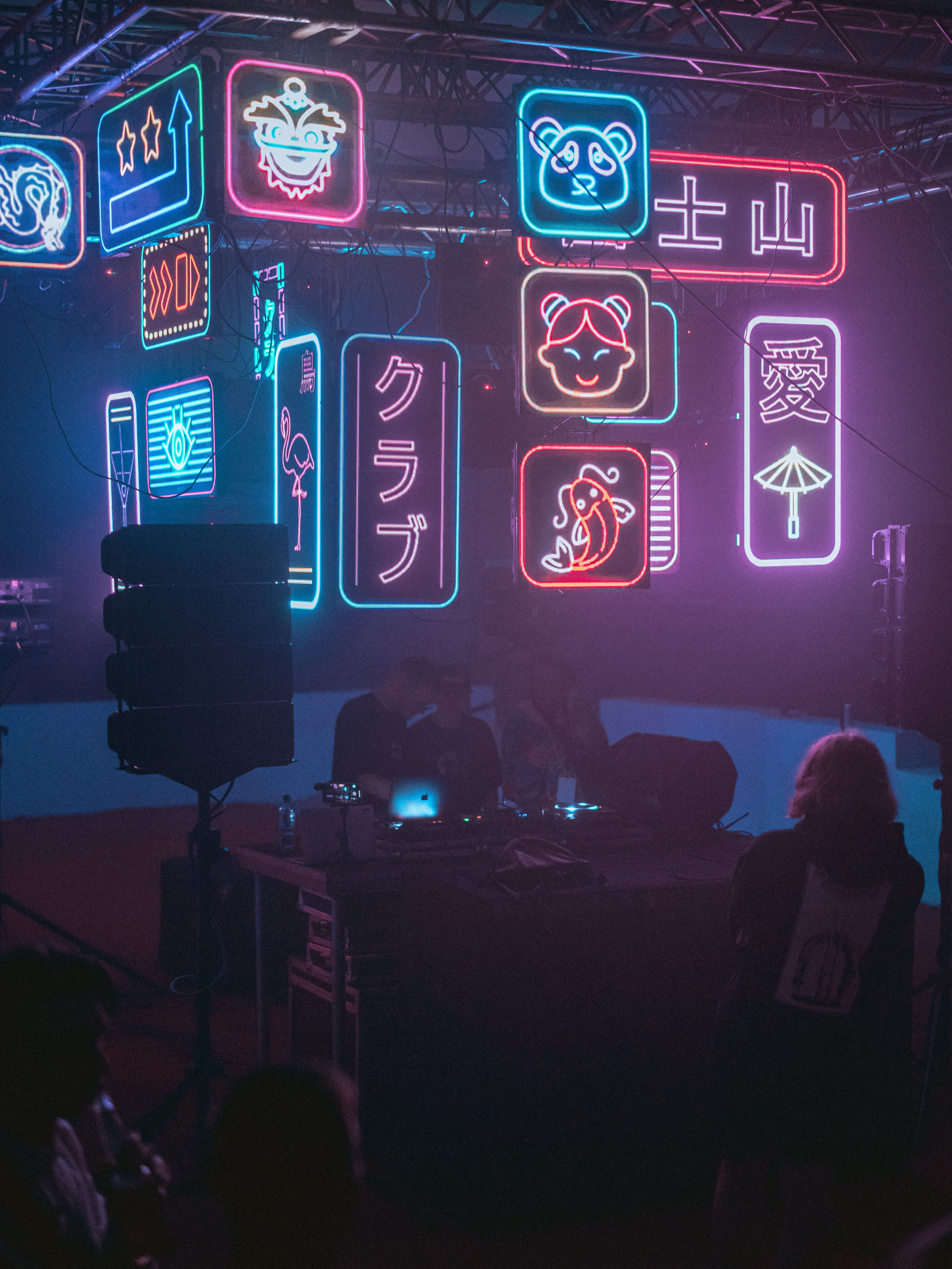 a group of people in a dark room with neon signs