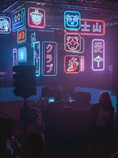 a group of people in a dark room with neon signs