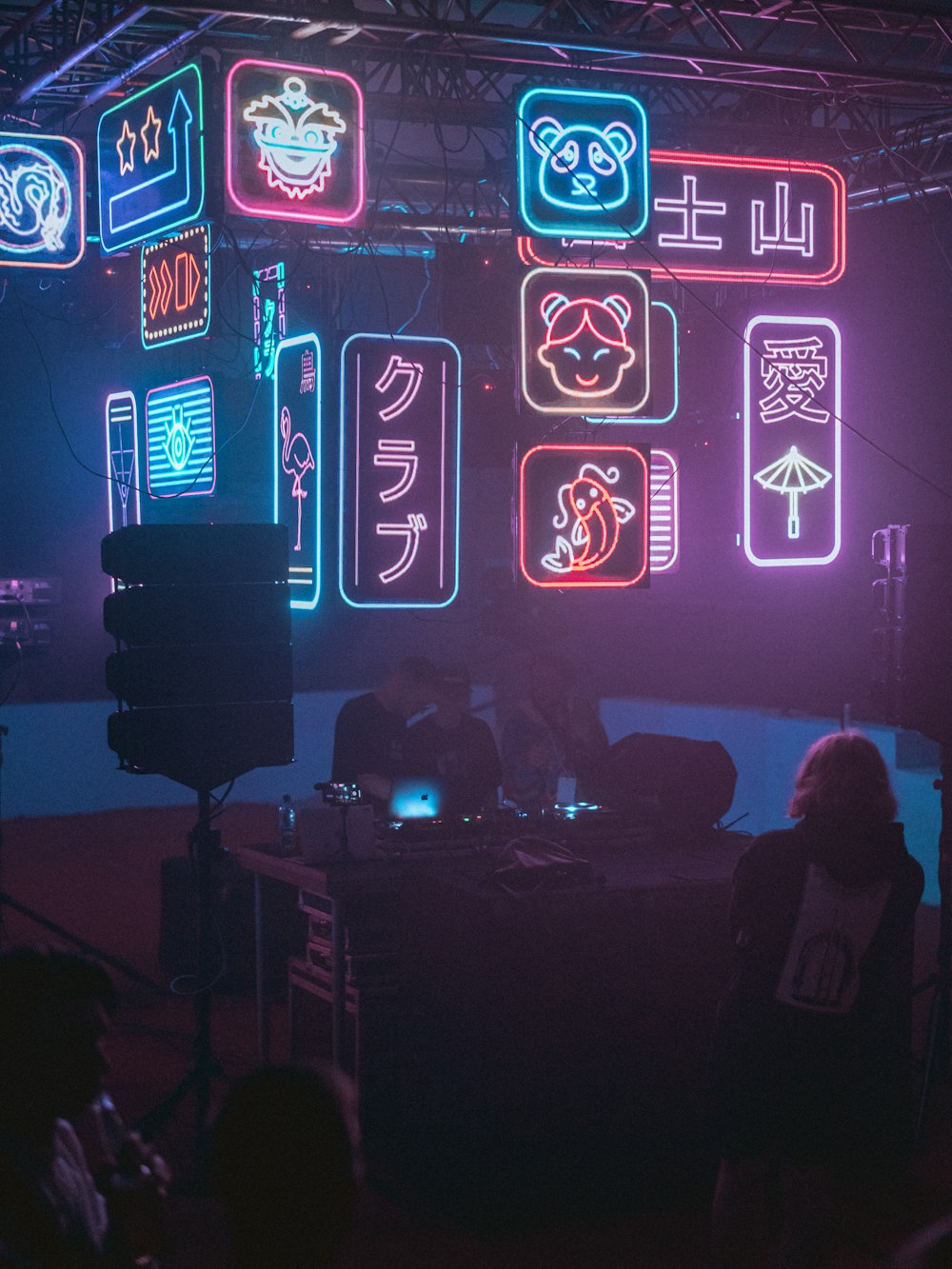 a group of people in a dark room with neon signs