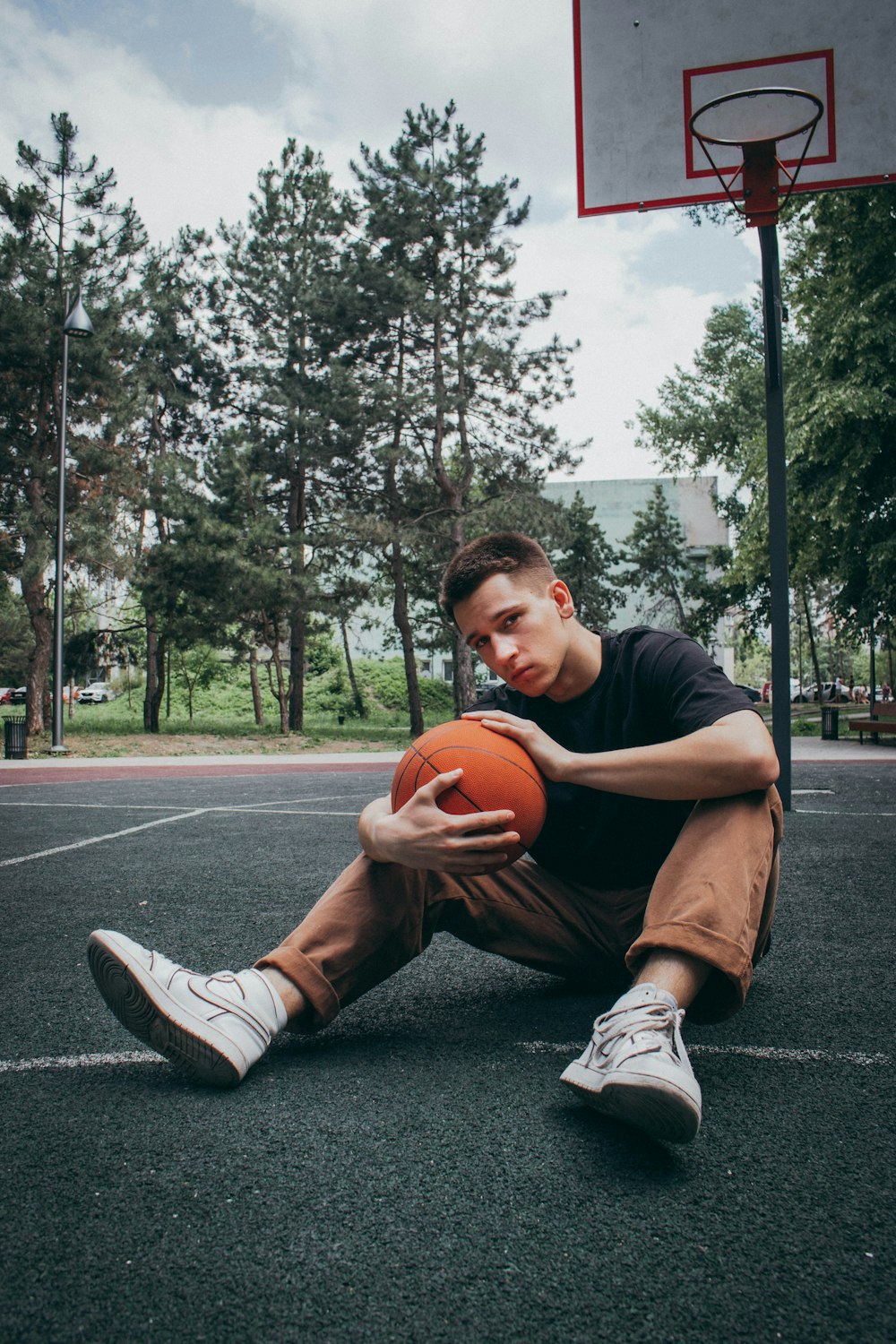 a man sitting on the ground holding a basketball