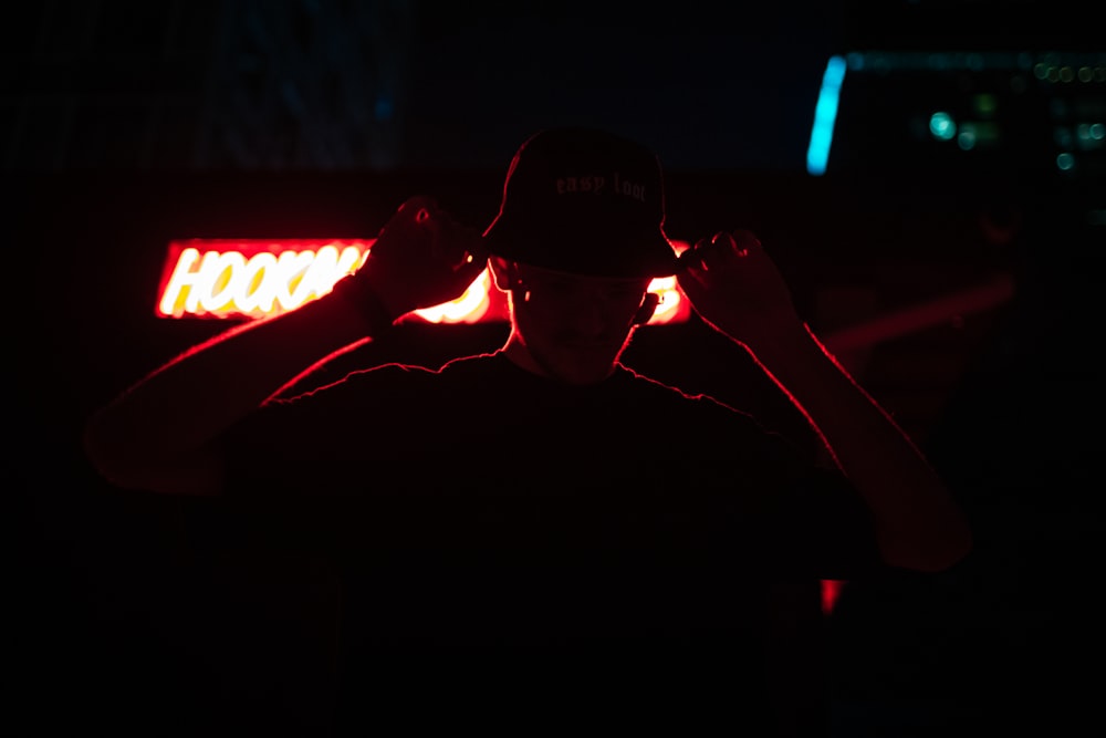 a person wearing a hat and holding a light up to the face