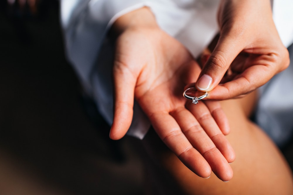 a close-up of hands holding a ring