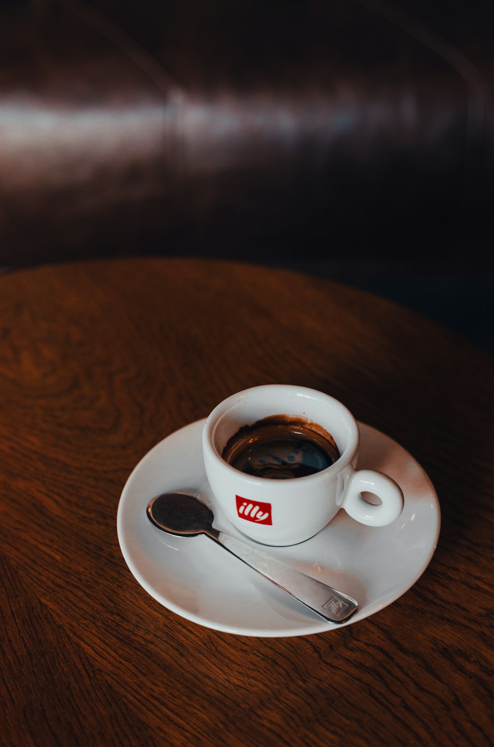 a cup of coffee on a saucer with a spoon