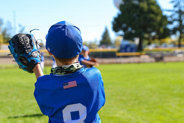 Baseball glove decorated with a vibrant blue strike showcasing the player's name and a star symbol.