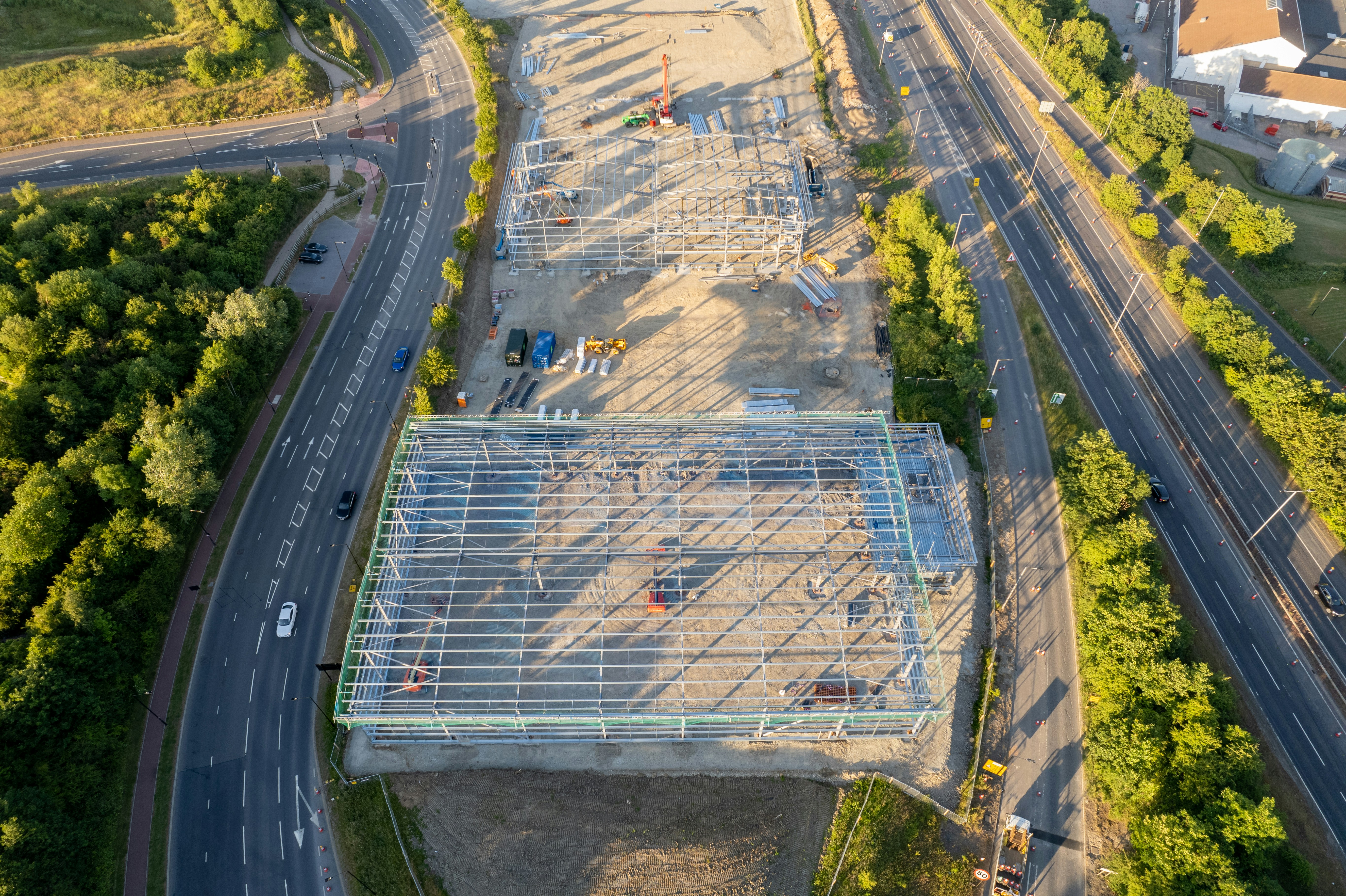 a large stadium with a road and trees around it