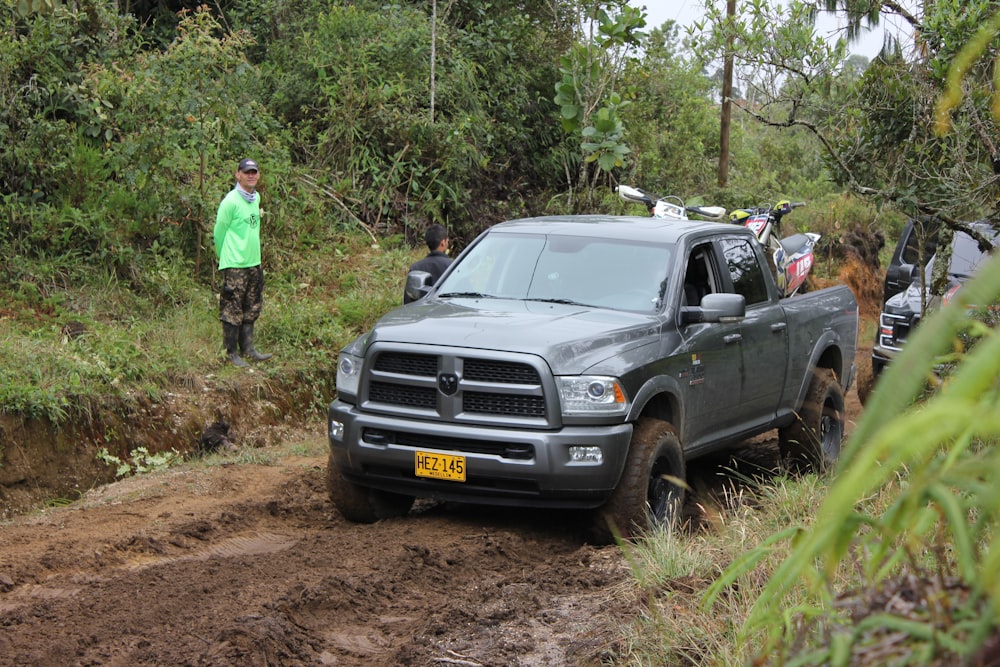 a car on a dirt road with people standing on the side