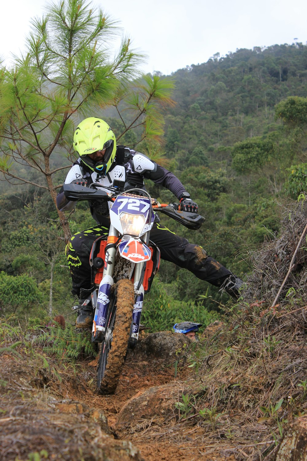 una persona montando una moto de cross en un sendero de tierra