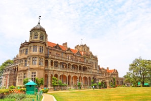 a large building with a lawn in front of it with Rashtrapati Niwas in the background
