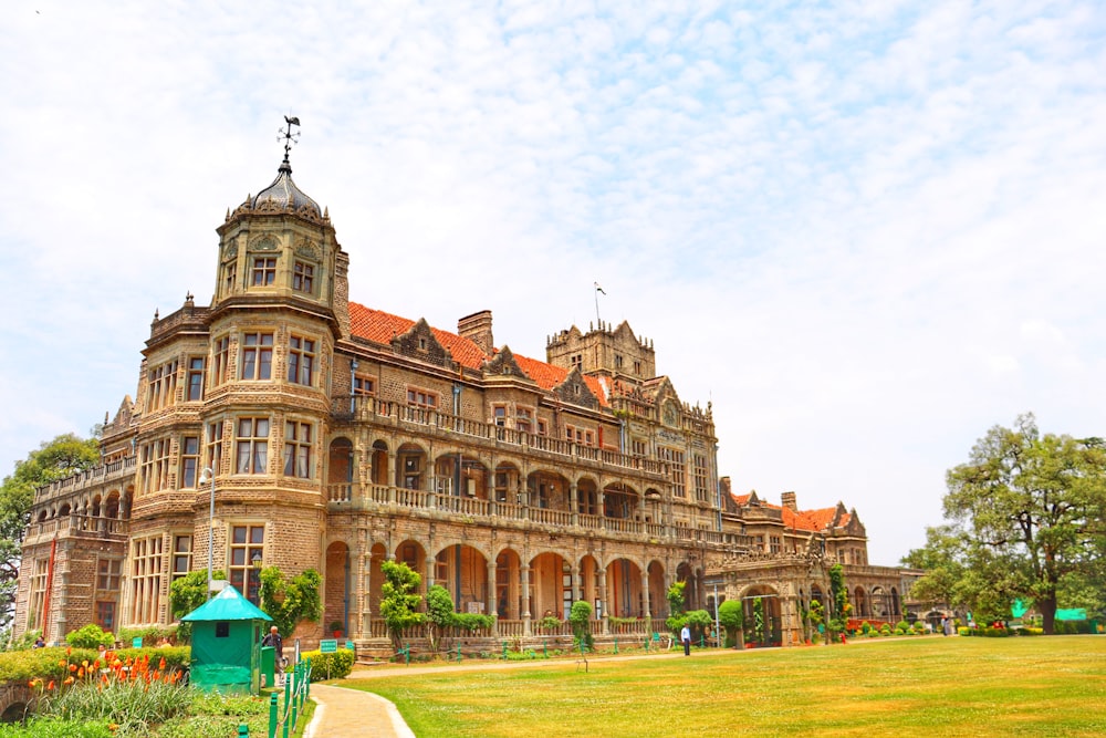 a large building with a lawn in front of it with Rashtrapati Niwas in the background