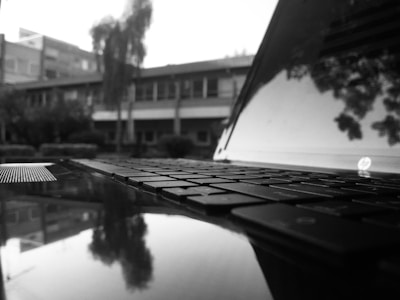 A focused trader meditating with a laptop in a minimalist black and white setting.
