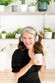 a woman wearing headphones and holding a cup