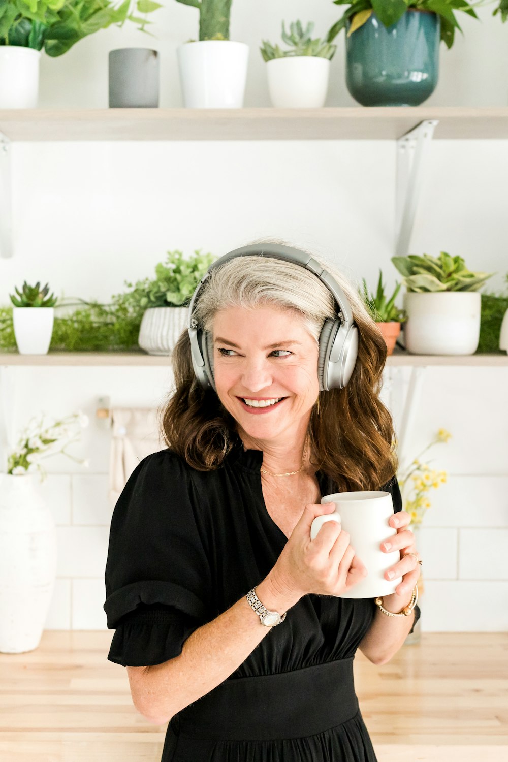 a woman wearing headphones and holding a cup